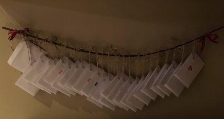 Adventní kalendář s příběhem pověšený na provázku v pokoji