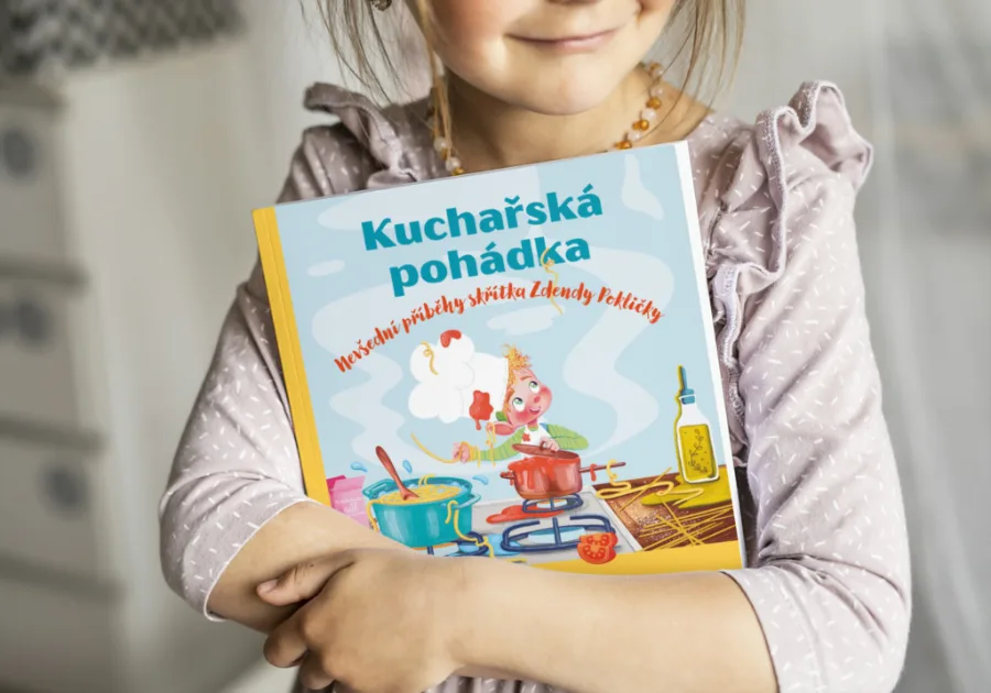 Holčička drží knížku Kuchařská pohádka se skřítkem Zdendou Pokličkou
